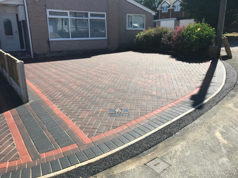 Two Adjacent Block Paved Driveways with a Fence in Holywell, Flintshire